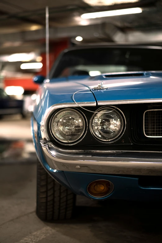 a blue ford mustang sits in a parking garage