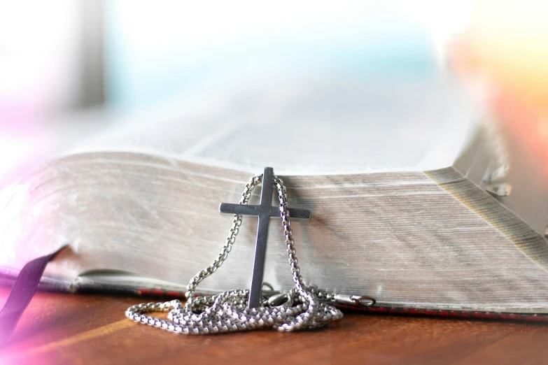 a cross hanging from a book on a table