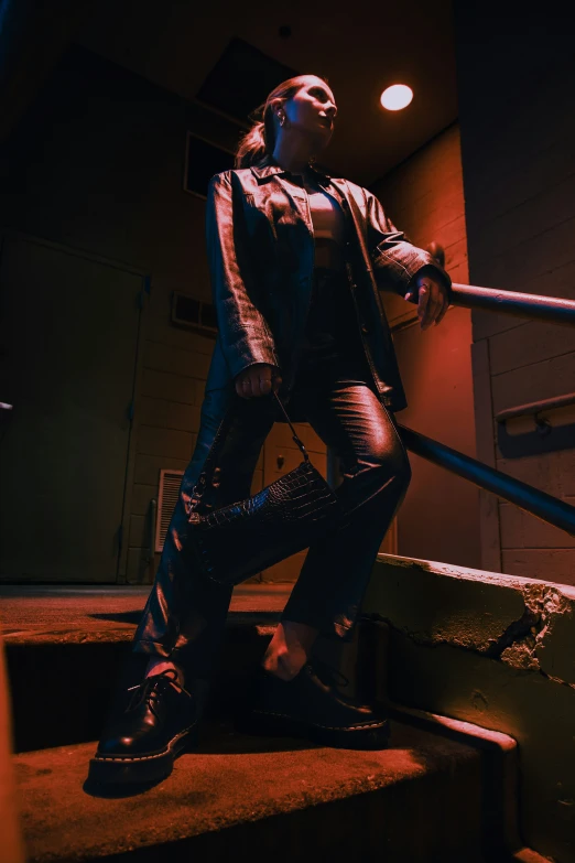 woman in leather costume posing with large sword on stairs