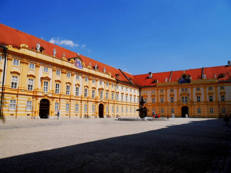 an old yellow building with a red roof