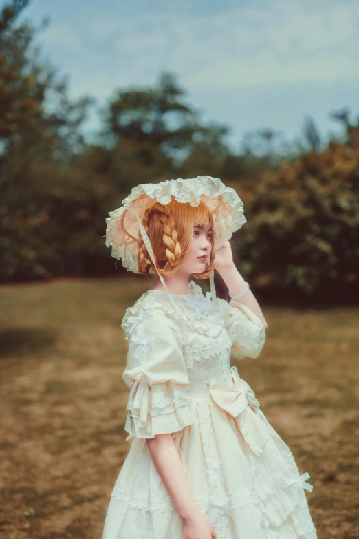 woman in a white dress with pink flowers on her hair stands outdoors