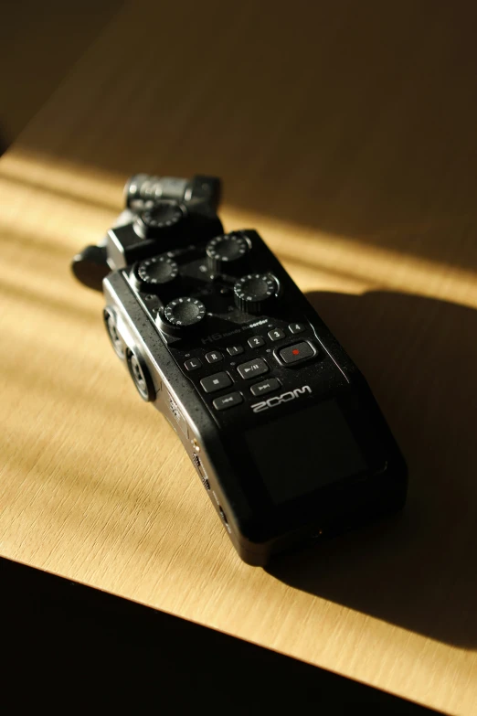 a close up of a cell phone remote on a table