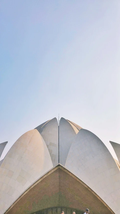 a group of people sit on the top of a large lotus shaped structure