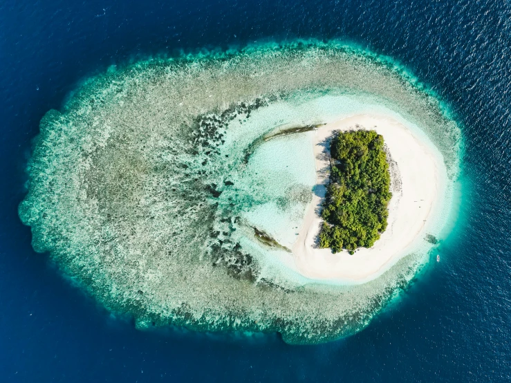 an island with a small white sandy beach next to water