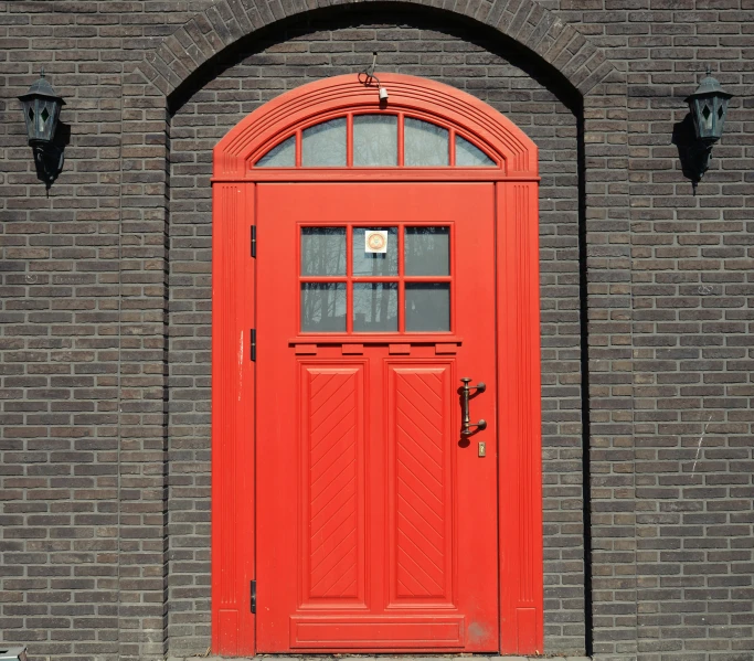 an orange fire hydrant in front of a brick building