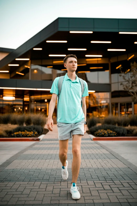 a young man with shorts and tennis shoes walks past an empty shopping center