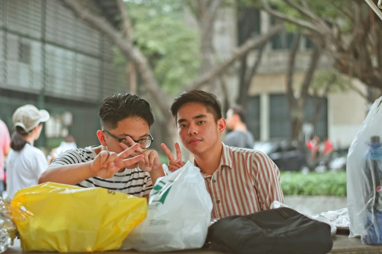 two men sitting down and looking at the same bag