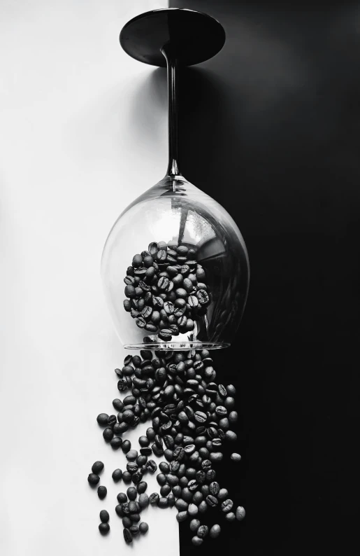 an unusual looking glass vase sitting on the floor next to coffee beans