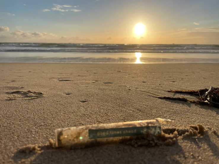 there is a bottle lying on the beach near the water