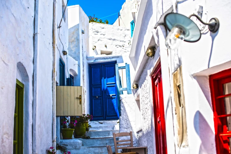 the entrance to a small alleyway that is painted white and features a bright blue door