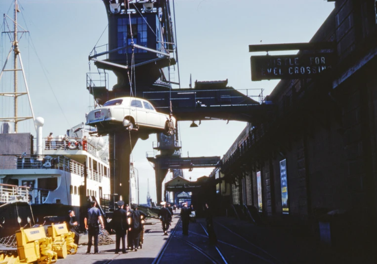 several people walk along the sidewalk next to a train platform