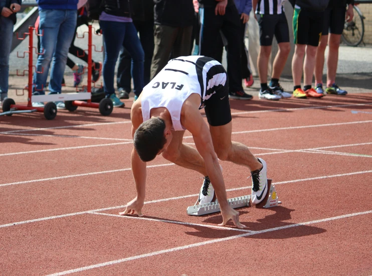 a woman crouched down on top of a track