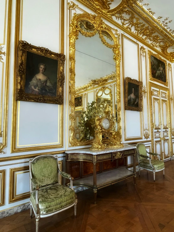 a room decorated with pictures, ornate wooden furniture and gilded ceilings