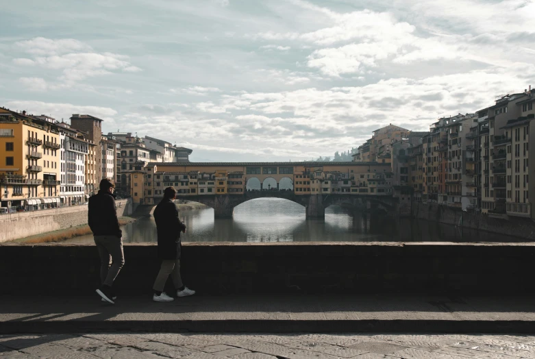 two people are standing near the water