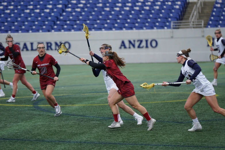 girls are playing lacrosse in a field full of bleachers