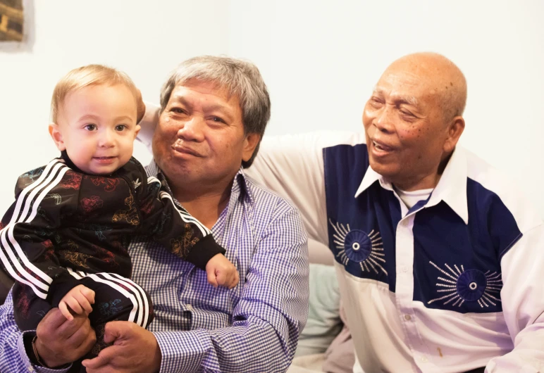 a man and boy are sitting side by side on the couch