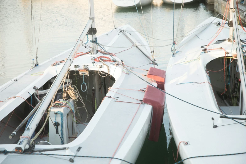 two white boats are docked side by side at a dock