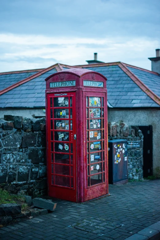 the two red telephone booths are placed in front of a building