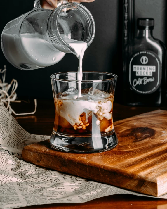 someone pouring sugar into a s glass to make an old fashioned  chocolate drink