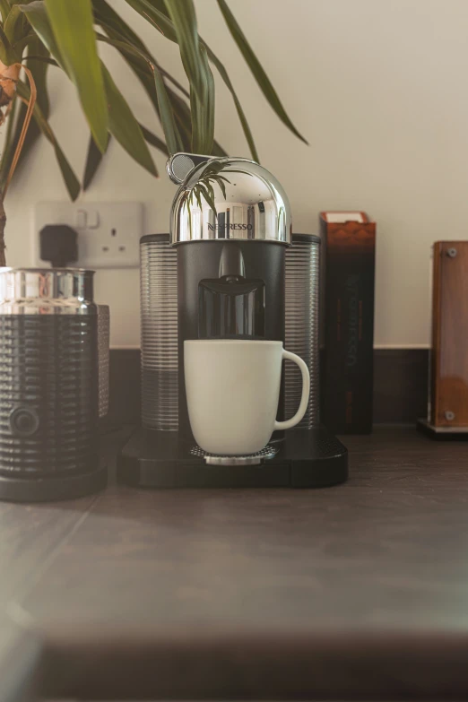 a coffee maker with a cup and water on it