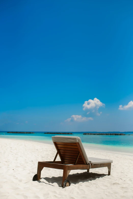 a beach chair sitting on the sand near water