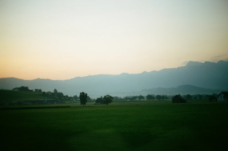 the green field is next to the mountains