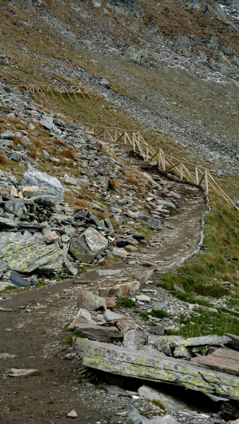 a mountain slope is partially covered with rocks and grass