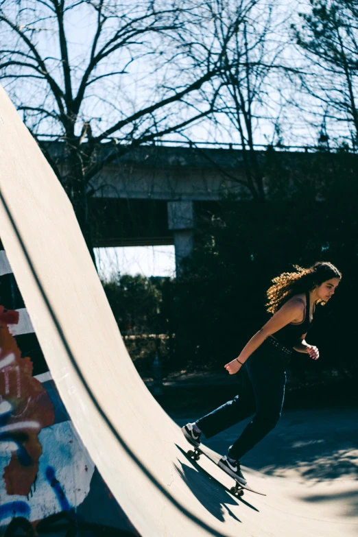 a girl riding a skateboard on top of a half pipe