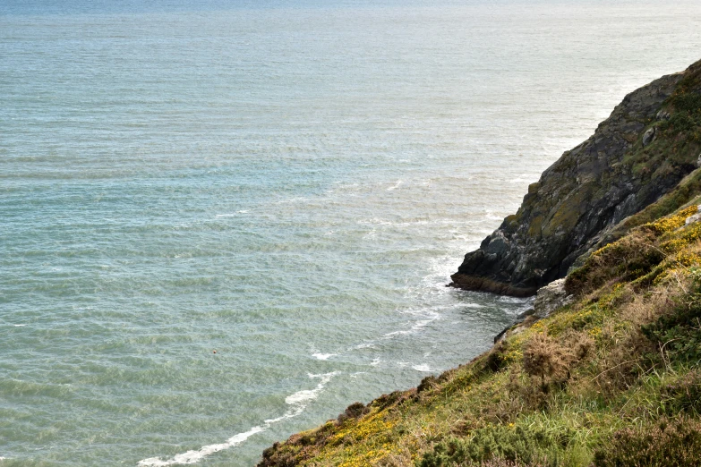 the beach has blue water near the cliff