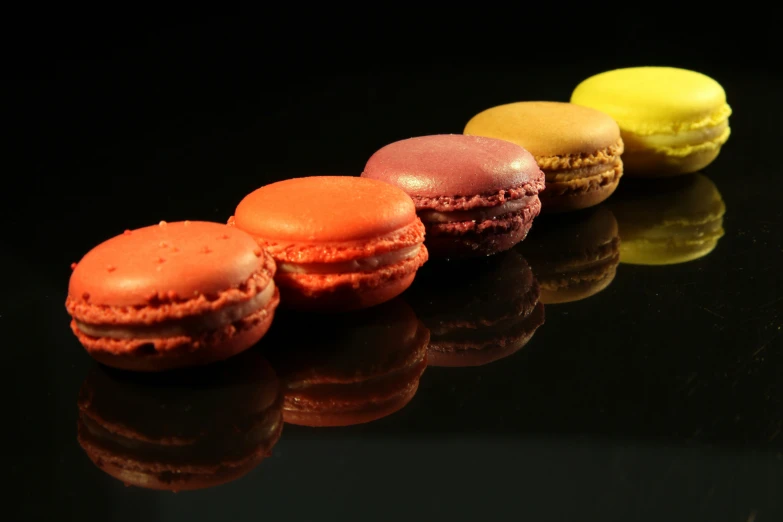 the three different kinds of macarons are on the black surface