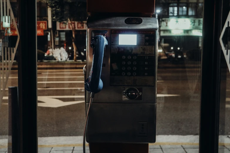 an old style telephone on a city street corner