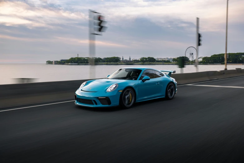 the new porsche sports car driving along a river