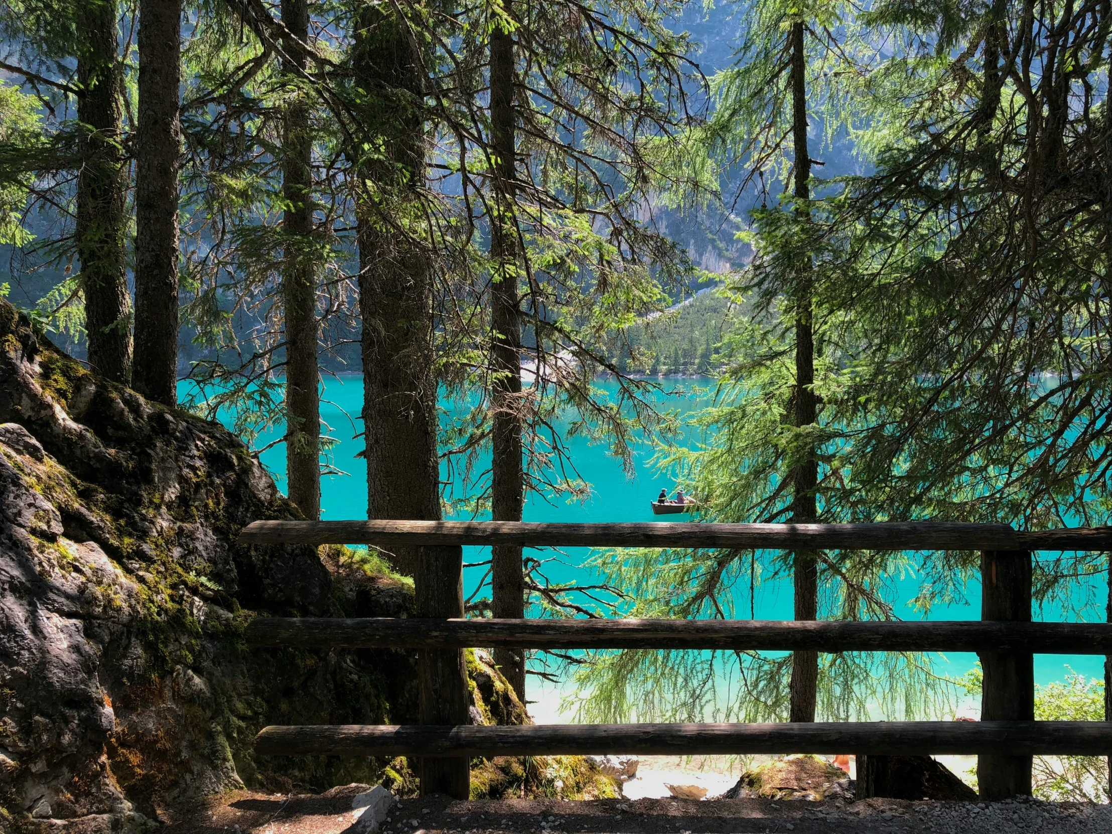 a park bench on a pathway in front of a lake