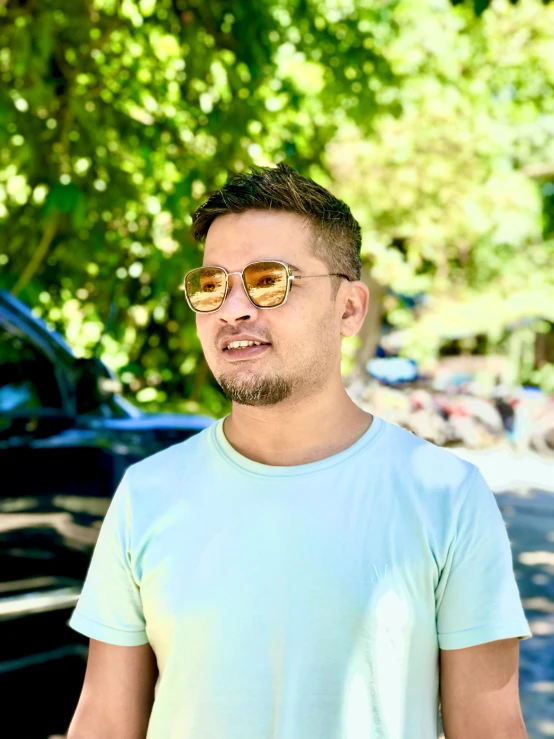 a man with sunglasses standing in front of a car