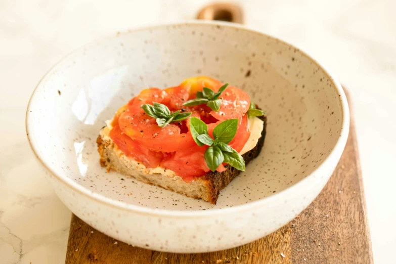 a large white bowl with a small sandwich in it