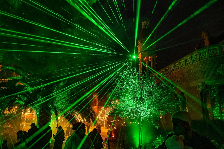 people standing under many green colored lights in the night