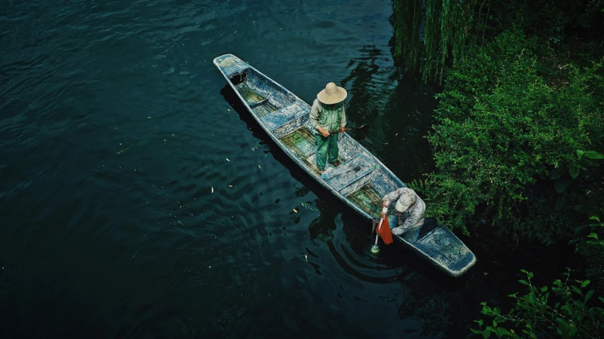 two men are paddling a boat along the river