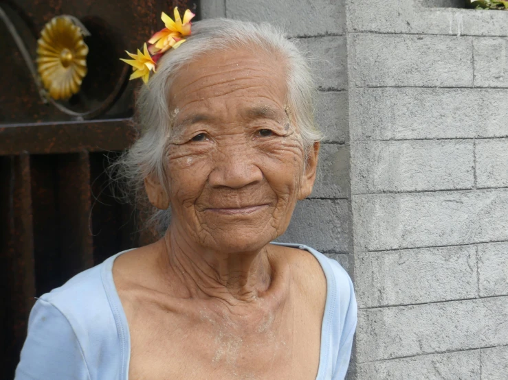 an elderly lady wearing a flower in her hair