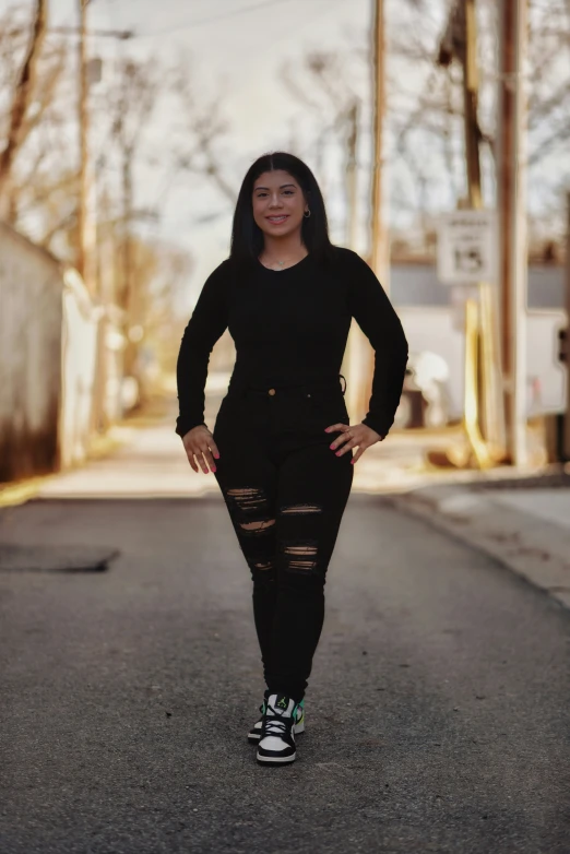 a woman in a black dress walking across a street