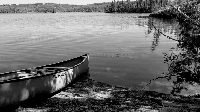 a canoe tied to a rock out on a lake