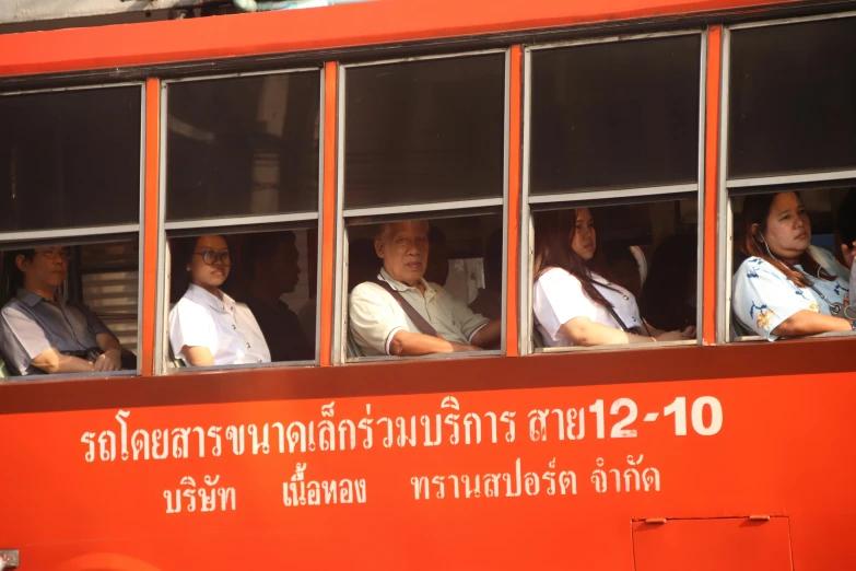 people in a window with orange doors on a bus