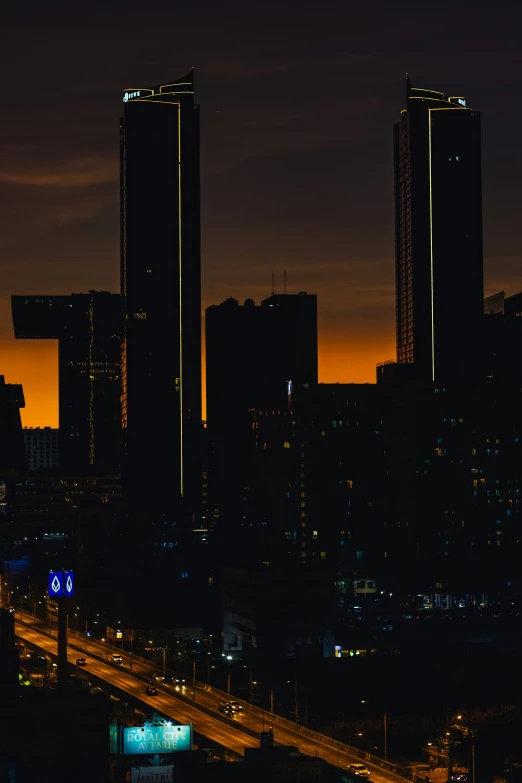 a city skyline with two large buildings at night