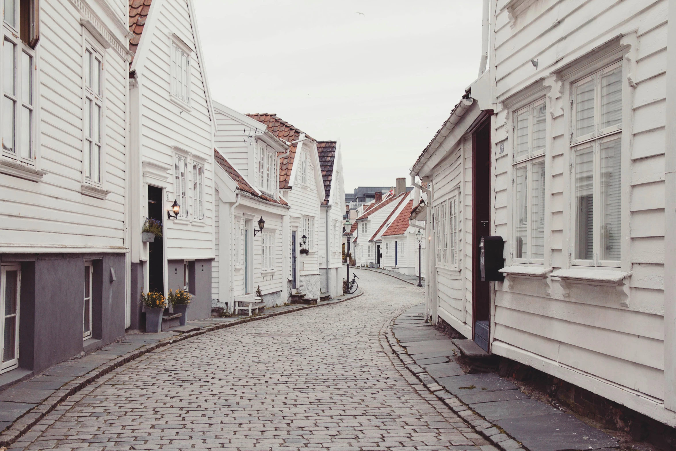 a cobble stone road leading through small white buildings