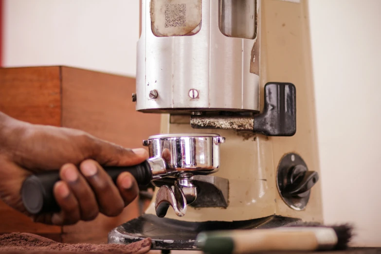 man using an old lathe to operate a coffee maker