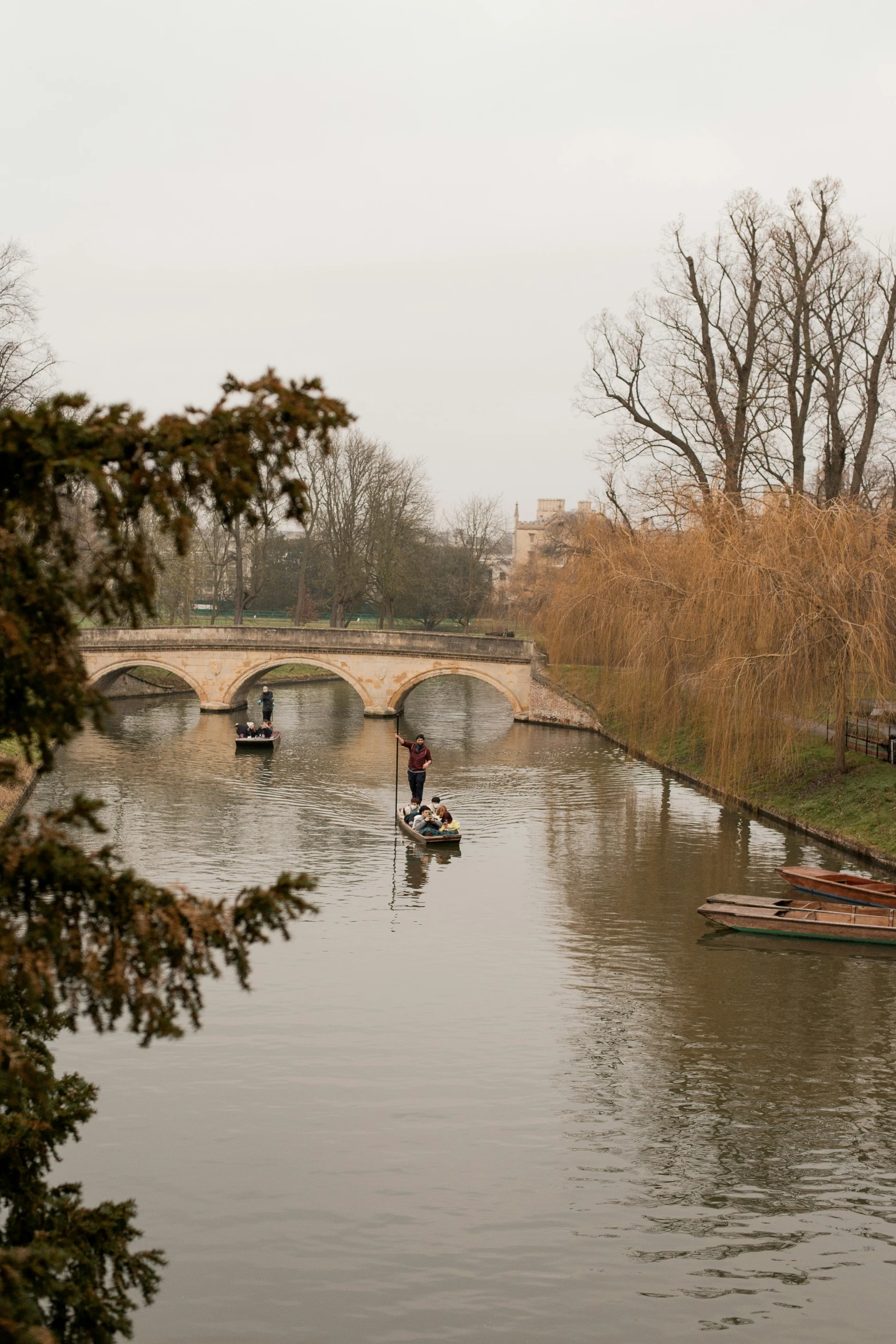 three boats are in the water with one man fishing