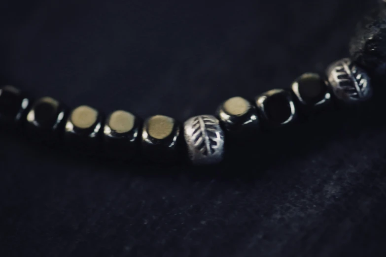 closeup of celet on black background with a silver tone bead