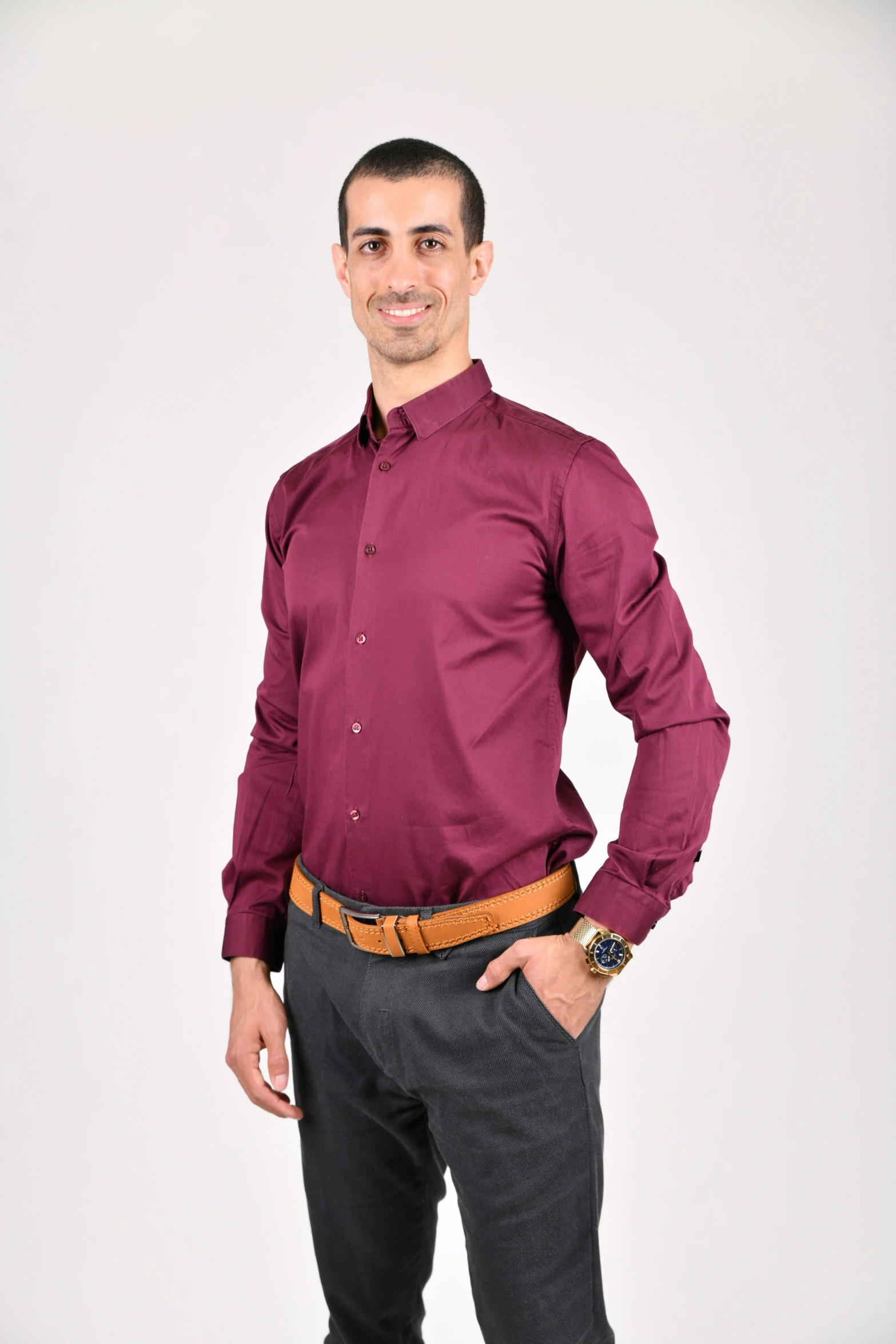 a smiling man in maroon dress shirt and gray suit pants