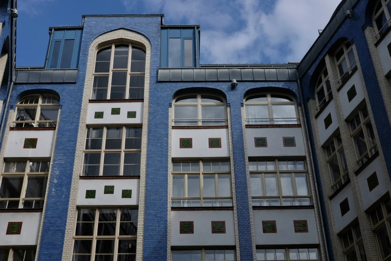 a tall brick building with multiple windows and lots of white walls