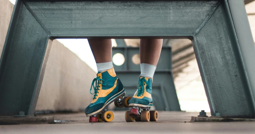 person's feet riding skateboards on an overpass