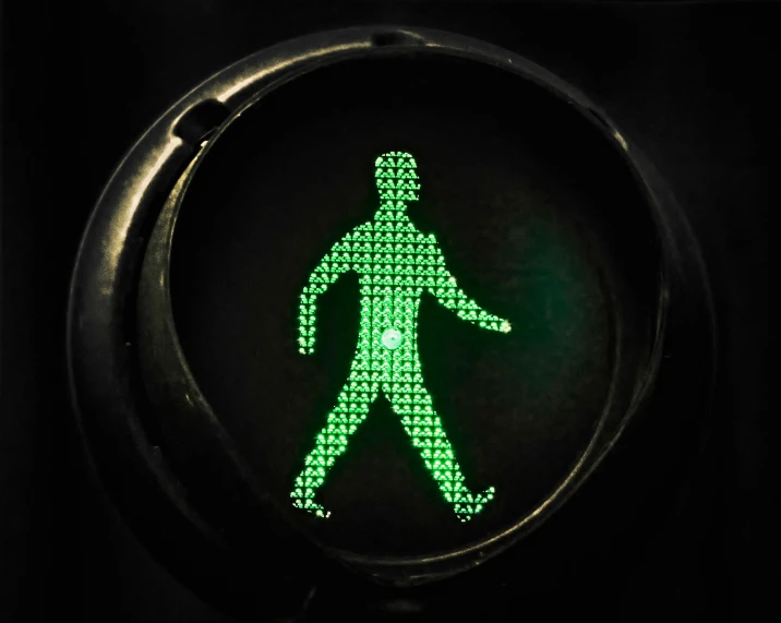 green man crossing signal on black background with words